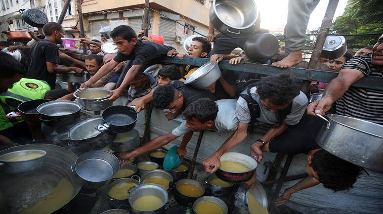 نازحون يتزاحمون للحصول على طعام مجاني من تكية خيرية في مدينة غزة