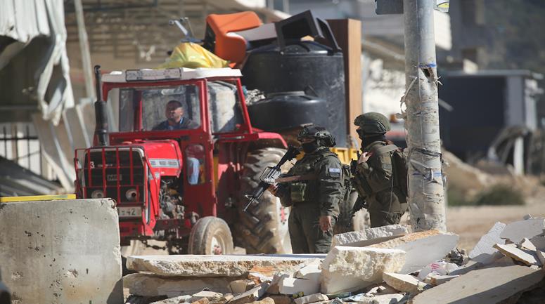 مواطنون يحملون أمتعتهم بعد إجبارهم على مغادرة منازلهم من قبل قوات الاحتلال في مخيم نور شمس شرق طولكرم