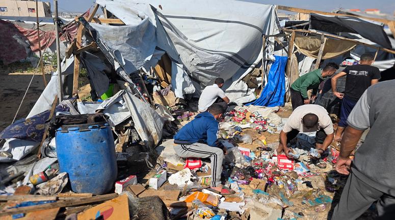 مواطنون يتفقدون موقع غارة إسرائيلية استهدفت خيمة في منطقة المواصي بخان يونس جنوب قطاع غزة