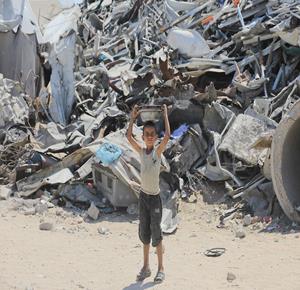 أطفال نازحون يحملون أوعية فارغة متجهين إلى مطبخ خيري يوزع وجبات مجانية شرق مدينة غزة
