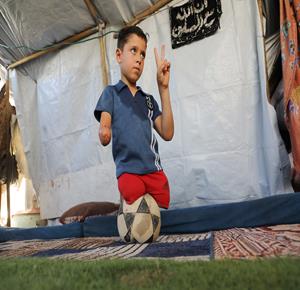 الطفل محمد شعبان، رغم بتر ساقيه وذراعه، يواصل ممارسة كرة القدم داخل خيمة النزوح في جباليا شمال غزة