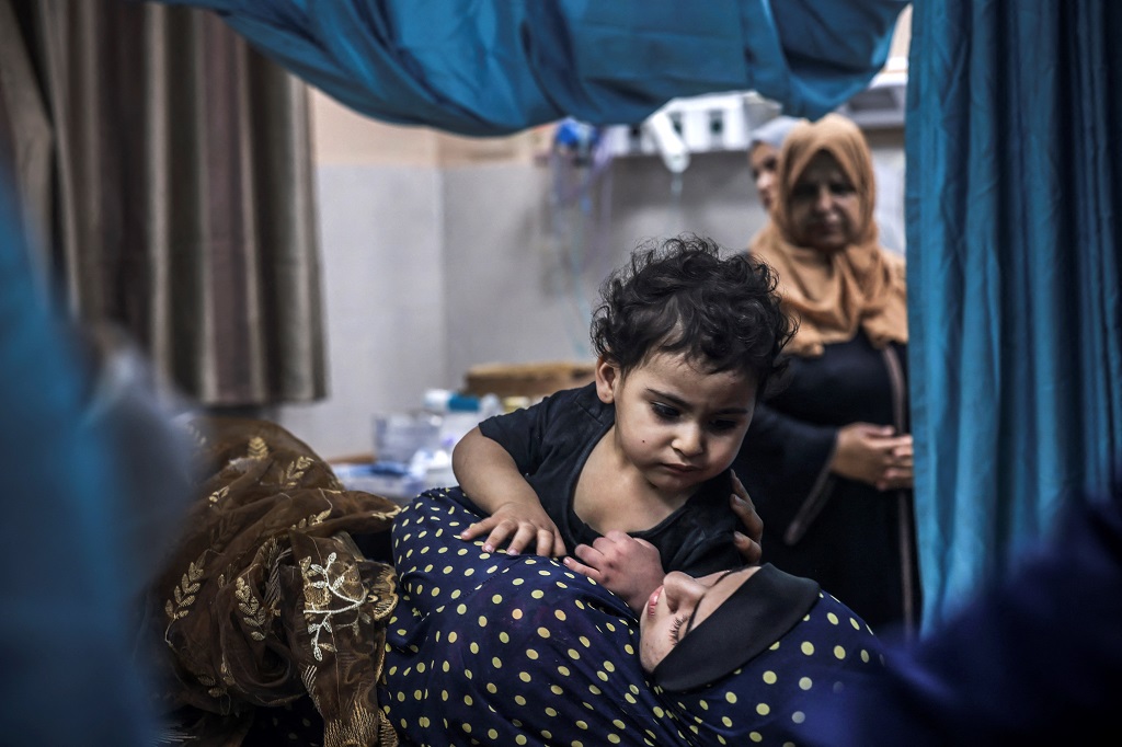 مواطنة وطفلها يتلقيان العلاج في مستشفى ناصر بخان يونس (تصوير: أ ف ب)
