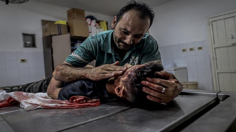 مواطن يودع جثمان نجله في مجمع الشفاء الطبي بمدينة غزة 