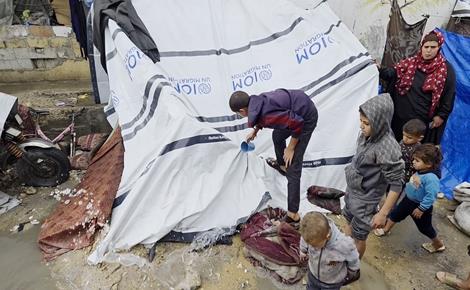 نازحون يحاولون إنقاذ خيامهم من الغرق في خانيونس 