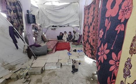 عائلة تحتمي من المطر والبرد في خيمة فوق الأنقاض 